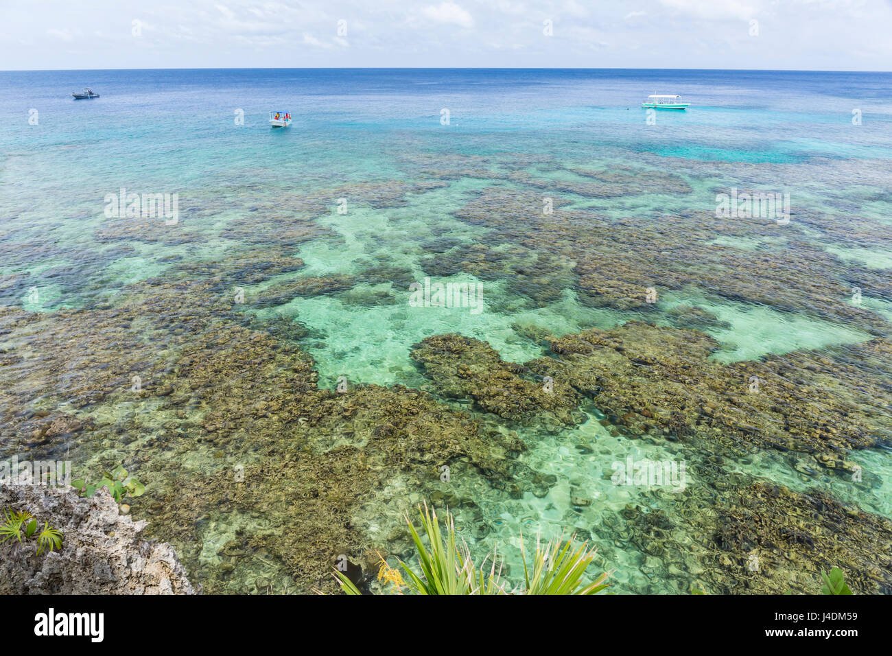 Los barcos de buceo en las aguas cristalinas cercanas a la costa de hierro de la barrera de coral de Roatán en West Bay, Roatán, Honduras Foto de stock