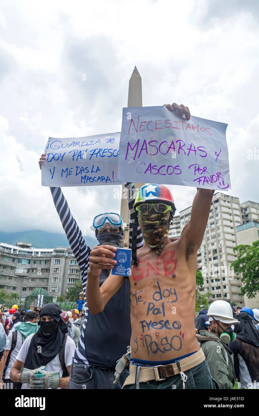 Un joven sostiene un cartel que indica ... Necesitamos máscaras y cascos, por favor. Bajo el lema 'nuestro escudo es la Constitución", o también llamado el 'Marco de los Escudos', los manifestantes comenzaron a concentrarse en diferentes partes de la ciudad para llegar a un Tribunal Supremo de Justicia (TSJ). Caracas, mayo,10,2017 Foto de stock