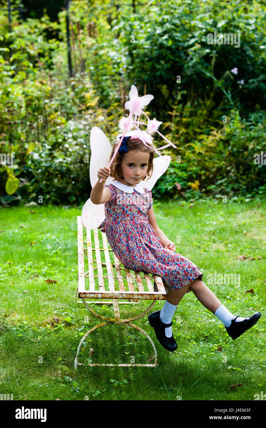 Vestirse - Una niña juega como un cuento en el jardín de verano de inglés Foto de stock