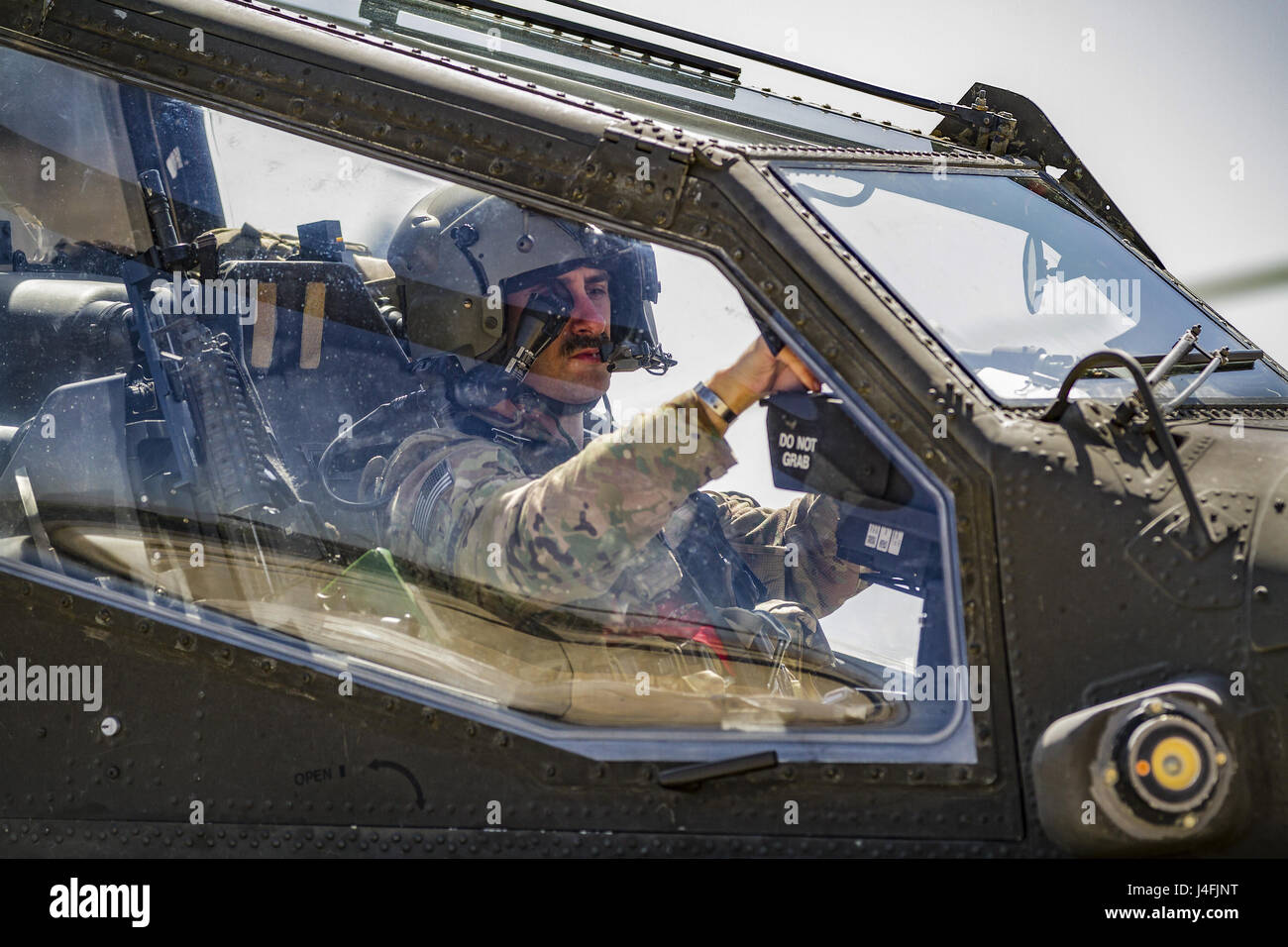 AH-64E piloto de helicóptero Apache se prepara para apartarse de una misión del aeródromo de Jalalabad, Afganistán Foto de stock