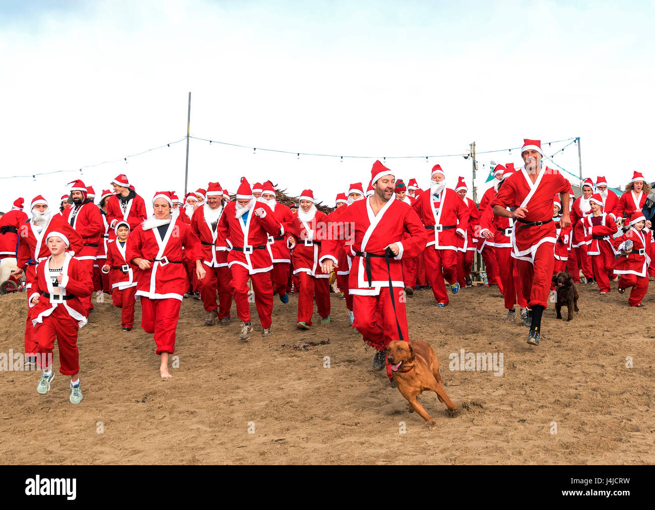 Perranporth, Cornualles, en el Reino Unido. El 18 de diciembre de 2016. Santa's en la arena una ejecución anual de caridad en Perranporth playa en Cornualles, Reino Unido Foto de stock