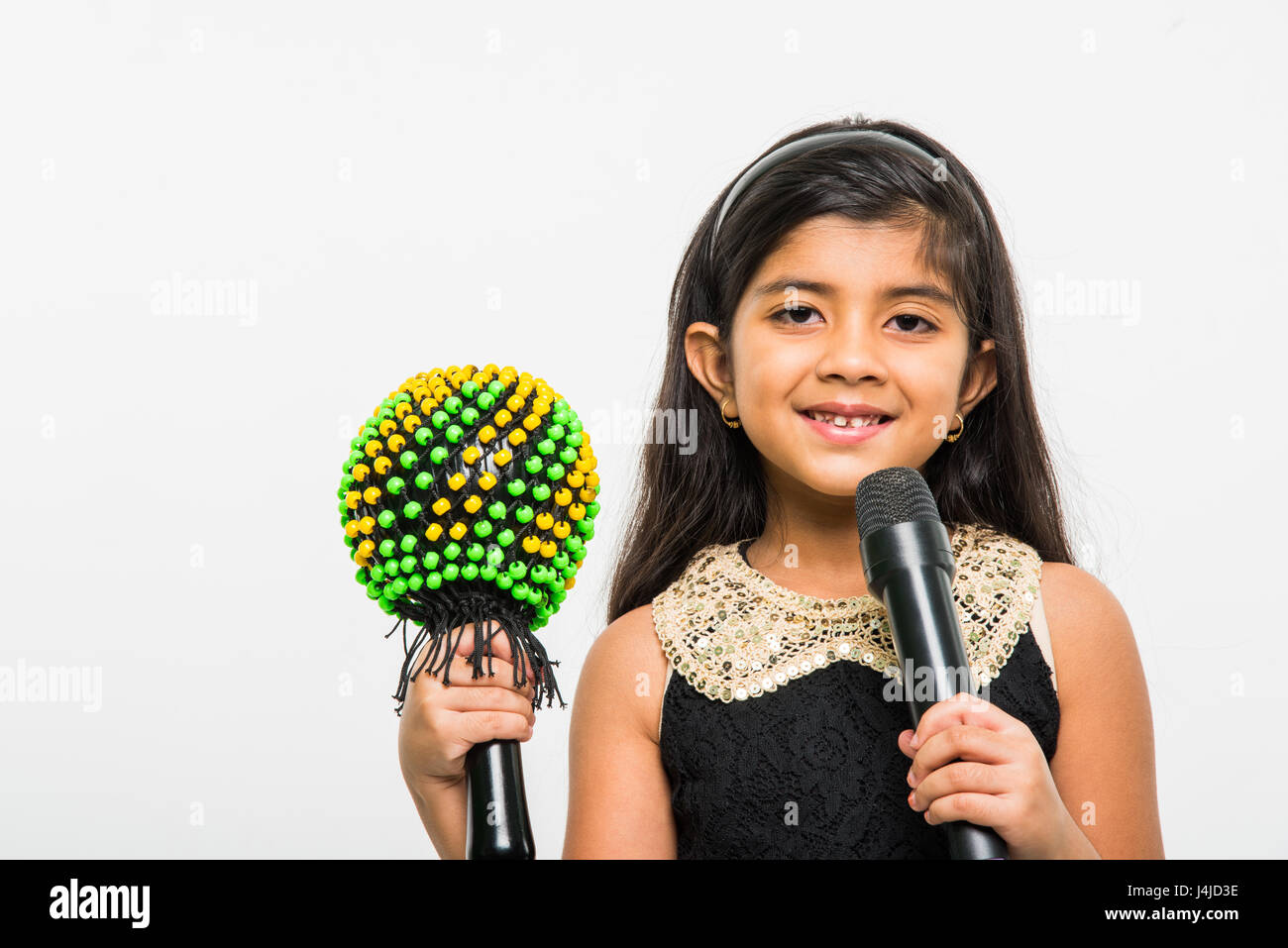 Linda niña India cantando en micrófono, de pie aislada sobre fondo blanco  Fotografía de stock - Alamy