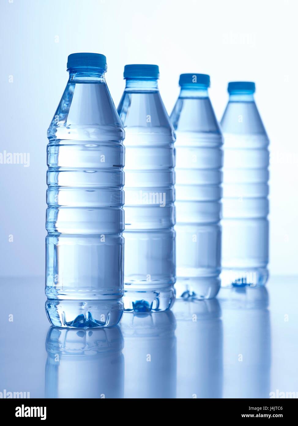 Cuatro botellas de agua mineral, Foto de estudio. Foto de stock