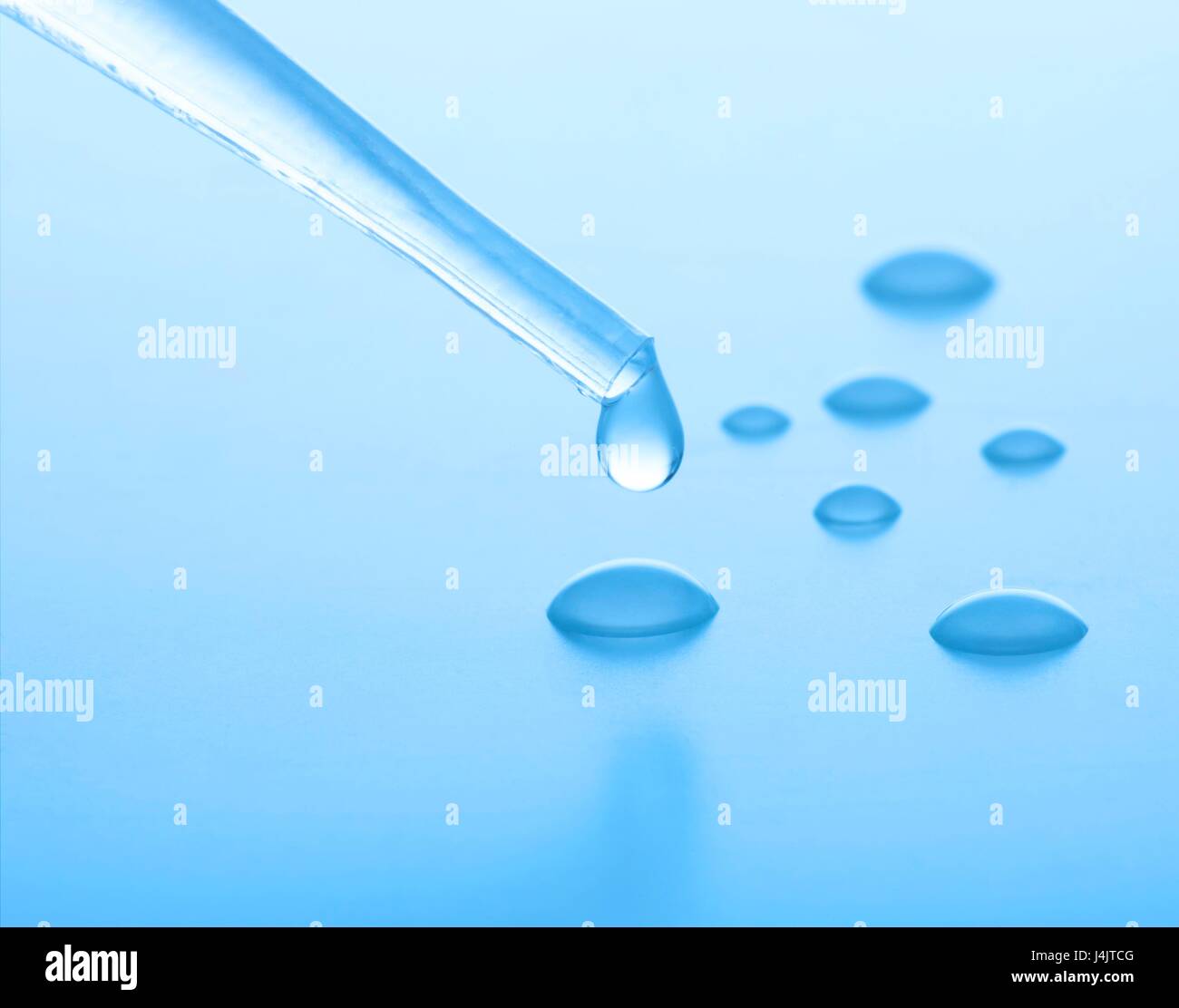 Las gotas de agua goteando de una pipeta, Foto de estudio. Foto de stock