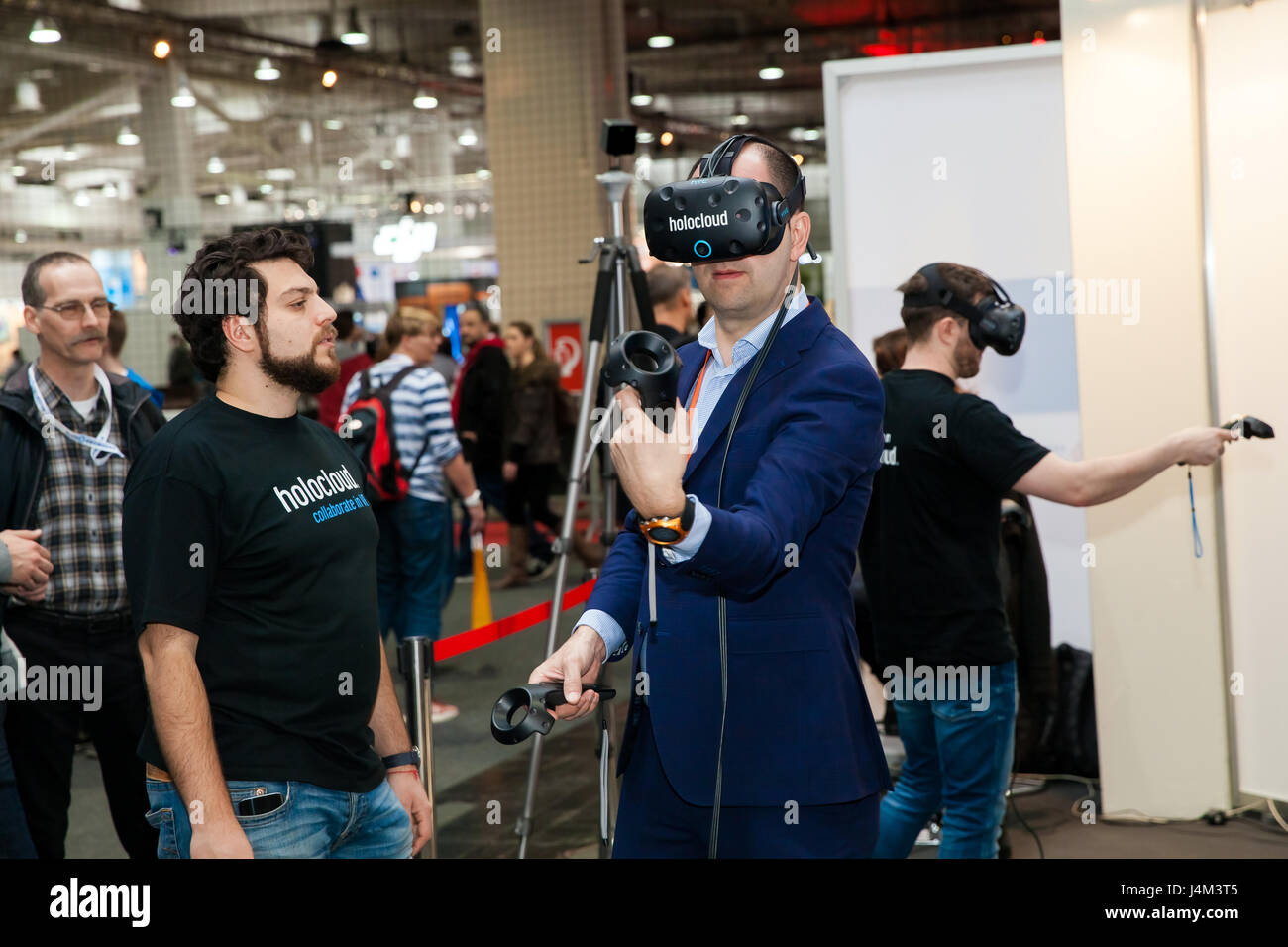 Hannover, Alemania - Marzo, 2017: el hombre video juego de casco de realidad virtual y los controladores de dispositivo desarrollado por HTC vive en la exposición Cebit 2017 en Foto de stock