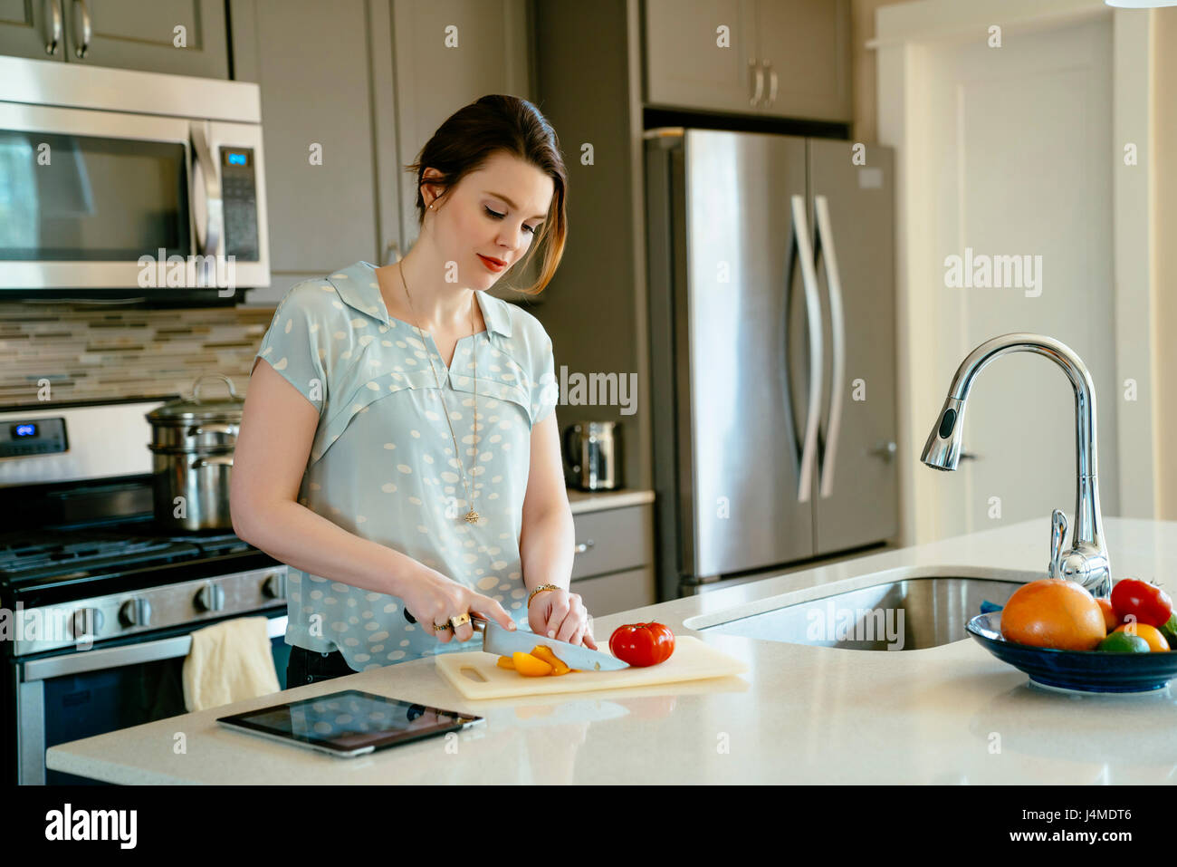 Mujer de picar alimentos en la cocina doméstica Foto de stock