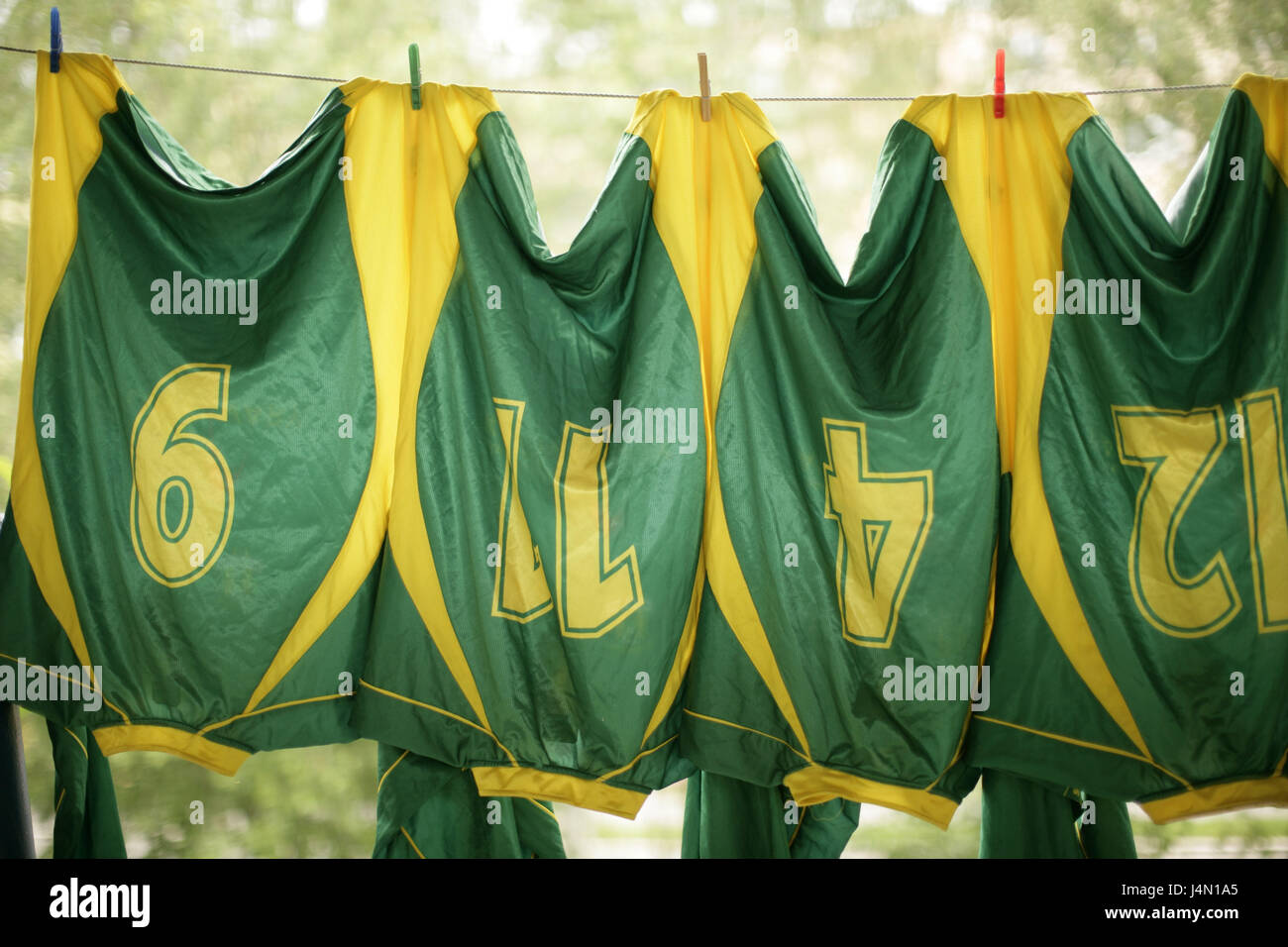 Tendedero, camisetas de fútbol, colgar, deporte, juego, verde, amarillo,  fútbol, números, figuras, tiempo de ocio, húmedo, limpieza, limpieza,  cuerda, seco, lavado, washday, equipo de fútbol, indumentaria, camisetas,  ropa deportiva Fotografía de stock -