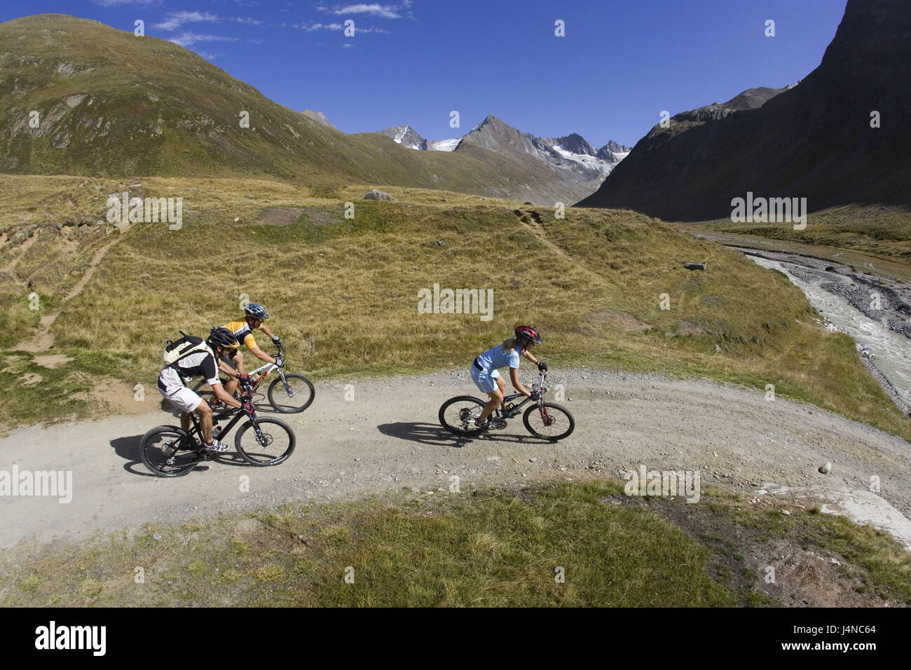 Austria, Tirol, Schönwies, conductor de bicicleta de montaña, pradera, arroyo de montaña, paisaje de montaña Foto de stock