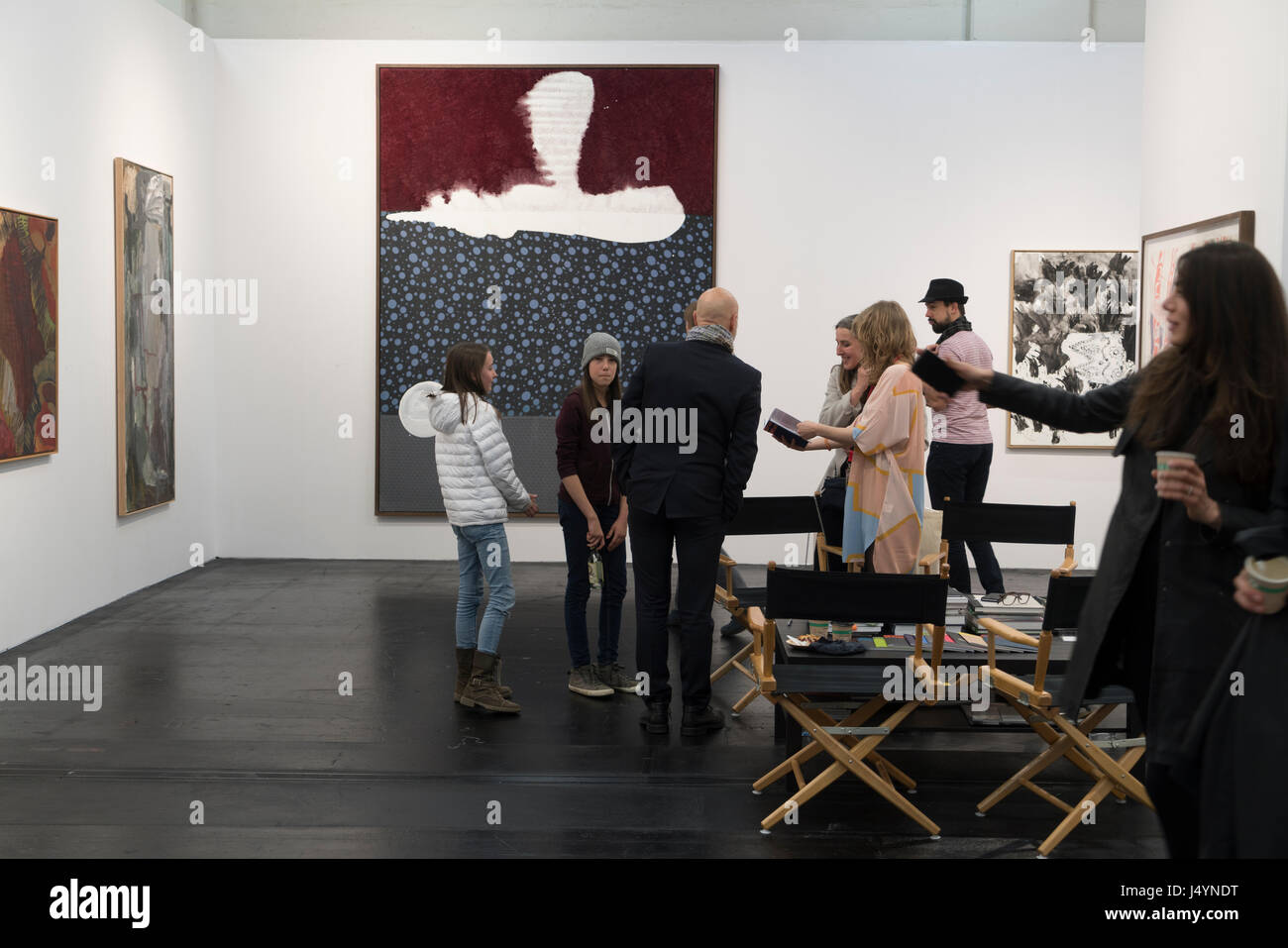 Las personas interesadas están hablando con la gente de ventas de una galería de Dinamarca. La gran imagen de fondo formuladas por Sigmar Polke. Foto de stock