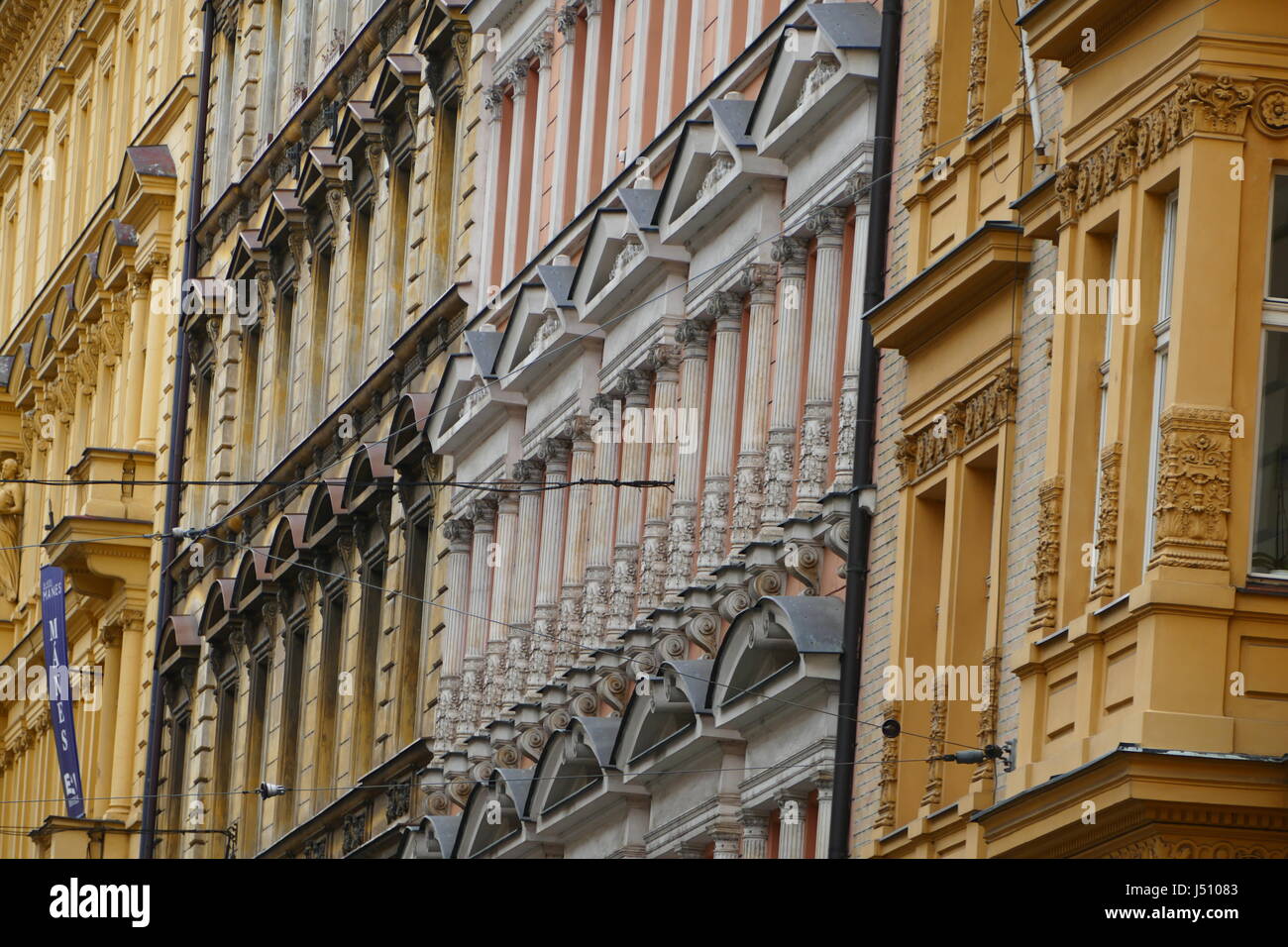 Muchas ventanas en una colorida sección de la maravillosa arquitectura de la ciudad de Praga. Mostaza, limón y edificios color salmón. Foto de stock