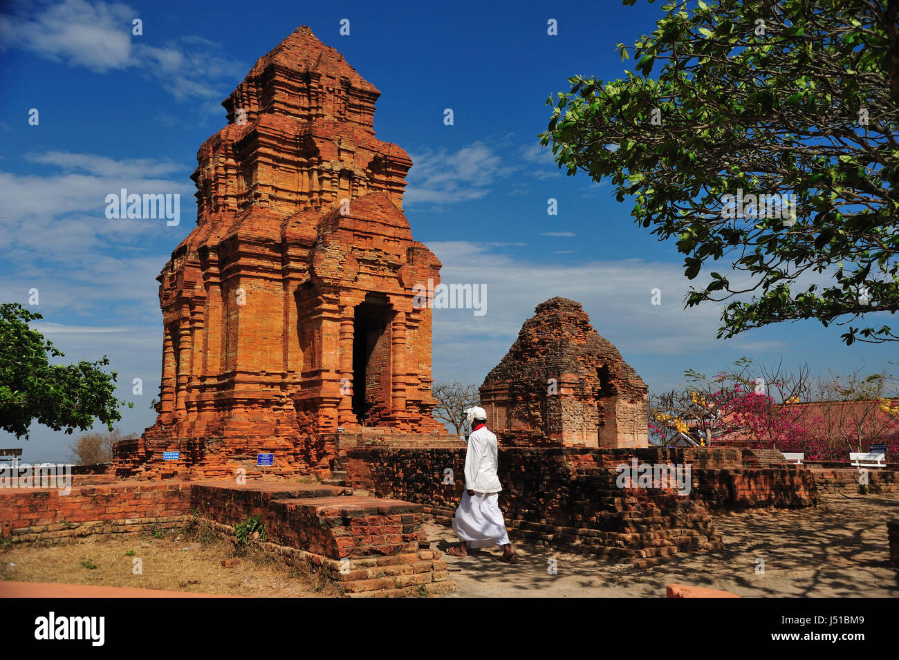 Un hombre con traje tradicional de Cham está caminando en Thap Po Sah Inu, templo del siglo xv torre Cham ruinas de Phan Thiet, provincia de Binh Thuan, Vietnam Foto de stock
