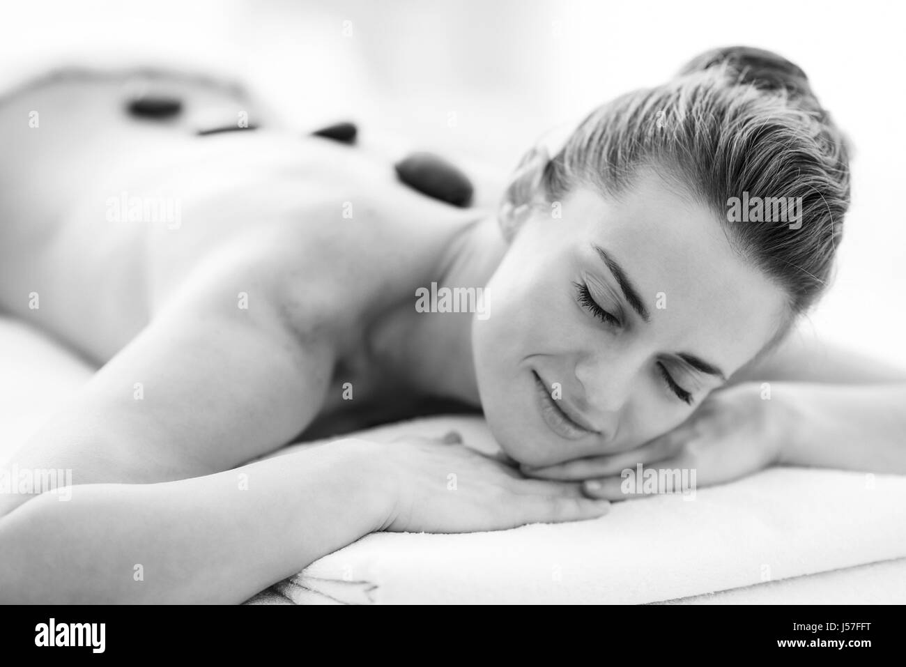 Retrato de relajado joven recibe el masaje con piedras calientes Foto de stock