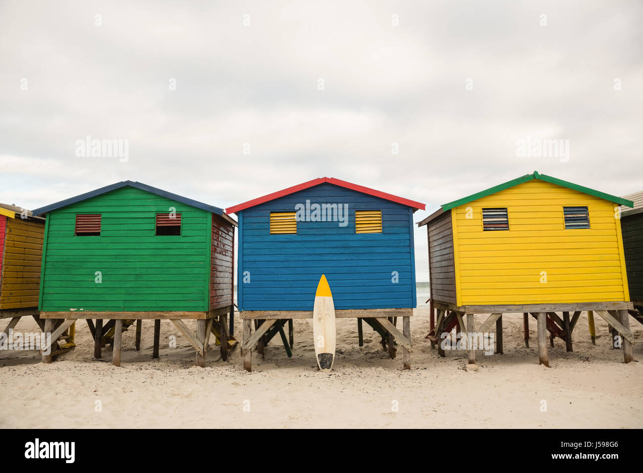 Cabañas de madera de varios colores sobre la arena en la playa Foto de stock