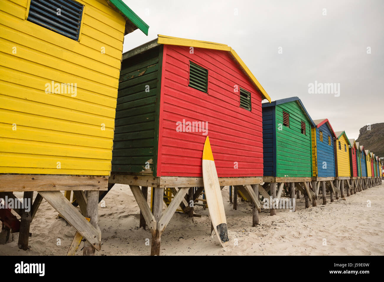 Cabañas de madera de varios colores en la fila en la playa Foto de stock