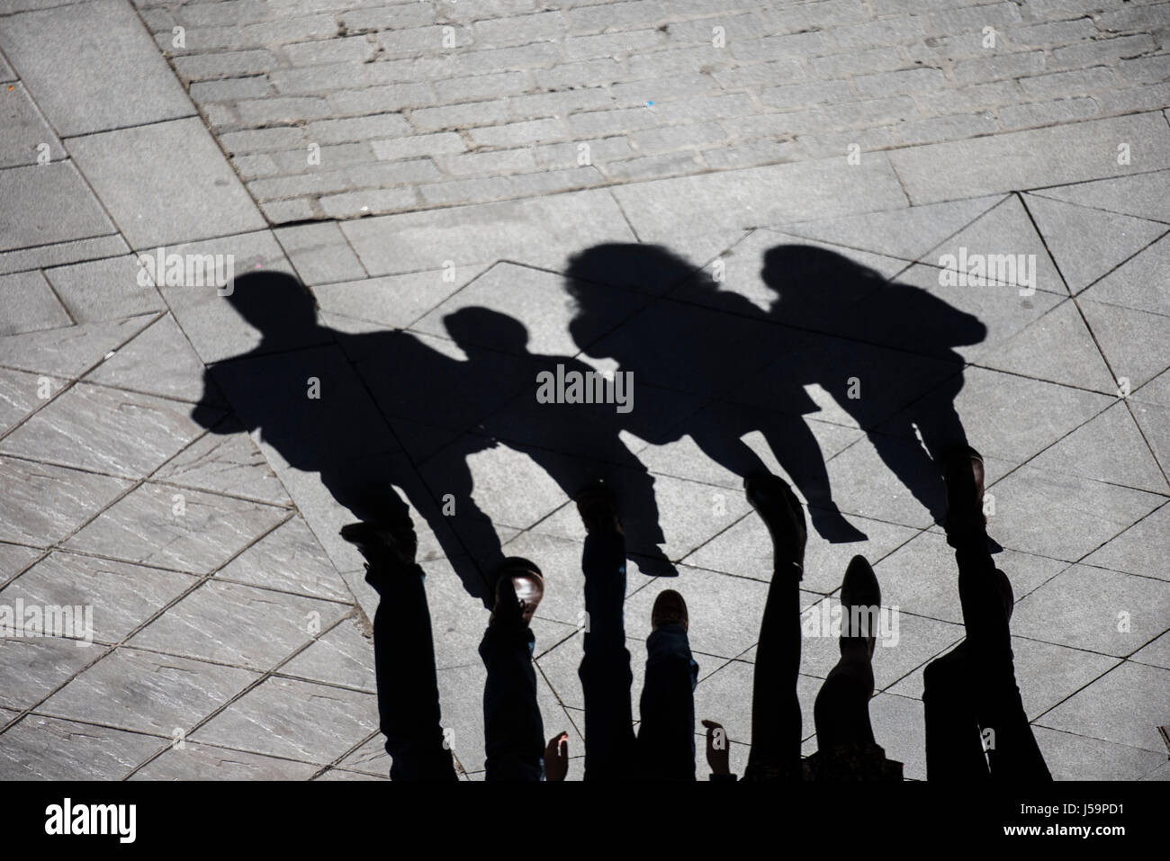 Las sombras y las siluetas de un grupo familiar (padre, madre, hijo e hija) caminando por la calle Foto de stock