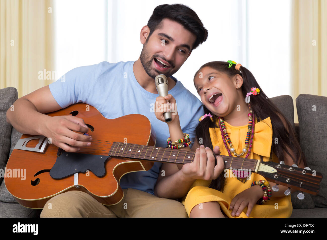 Padre e hija, cantando mientras tocando la guitarra Foto de stock