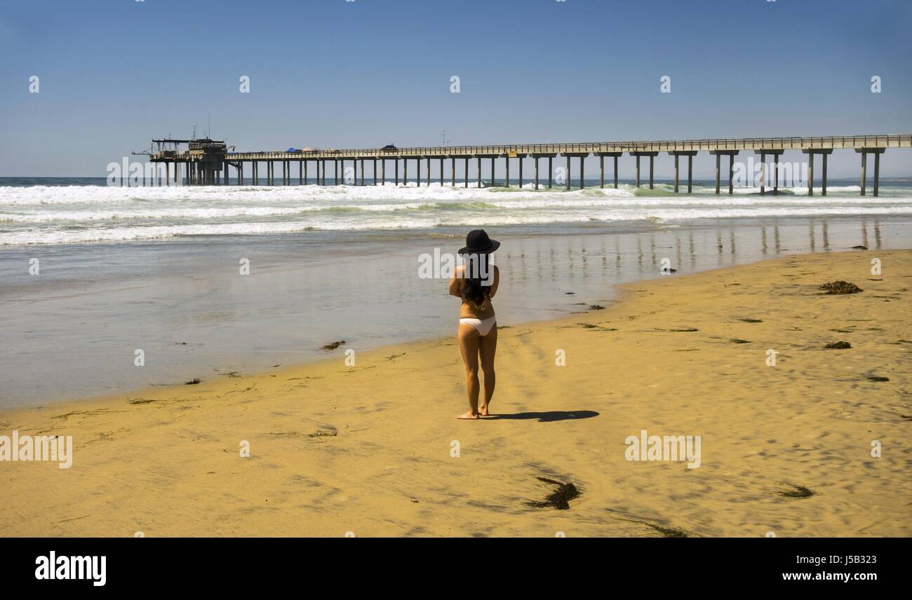 Mujer aislada en sombrero de moda y bikini amarillo en LA Jolla Shores San  Diego Beach mirando hacia Scripps Pier y. Horizonte del Océano Pacífico  Fotografía de stock - Alamy