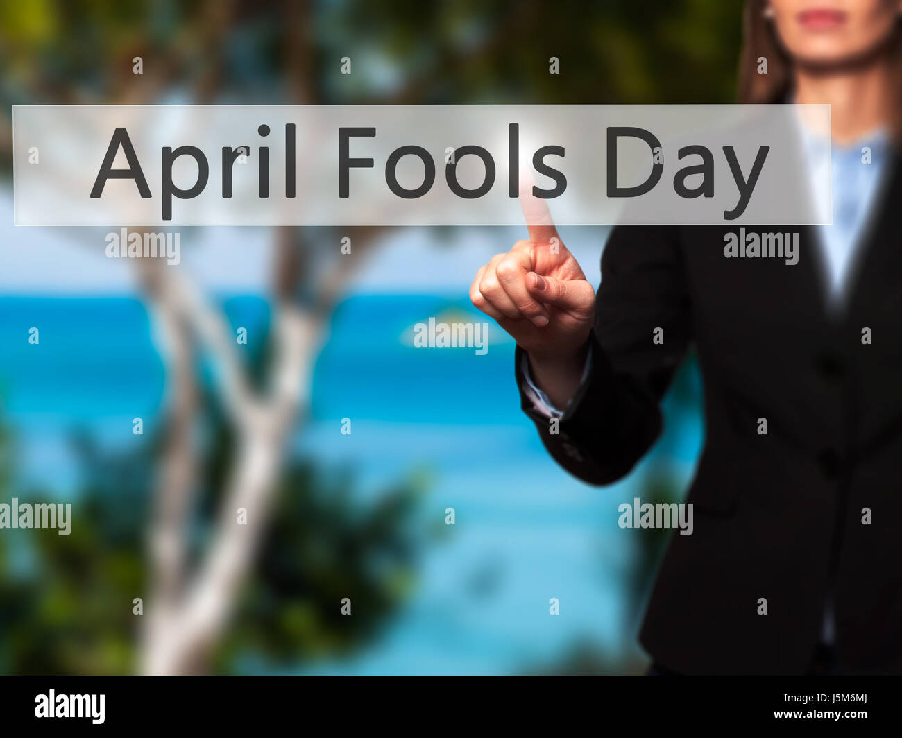 April Fools Day - Lado hembra aislado de tocar o apuntando al botón. Concepto de negocio y la tecnología del futuro. Stock Photo Foto de stock
