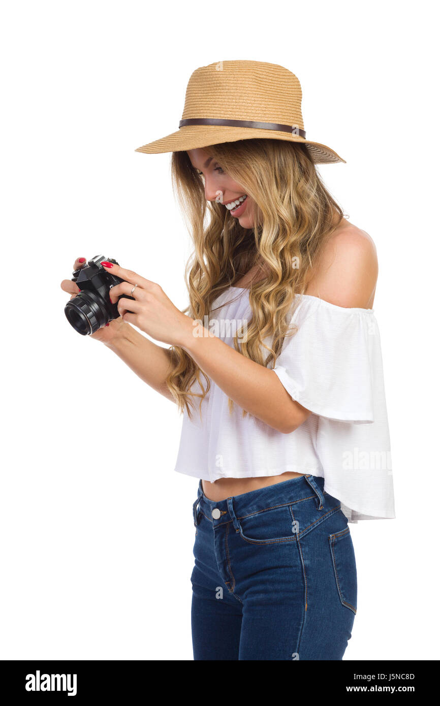 Mujer sonriente en jeans, camisa blanca y sombrero de paja Mujer sonriente en jeans, camisa blanca y sombrero de paja