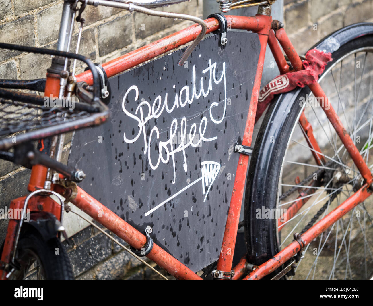 Una bicicleta de trabajo sirve como un anuncio para los números de caliente café Mill Road en Cambridge, Reino Unido Foto de stock