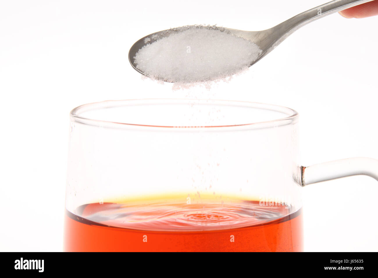 Cuchara de té azúcar insalubres calorías cáliz de vidrio vaso insalubres de  té Fotografía de stock - Alamy
