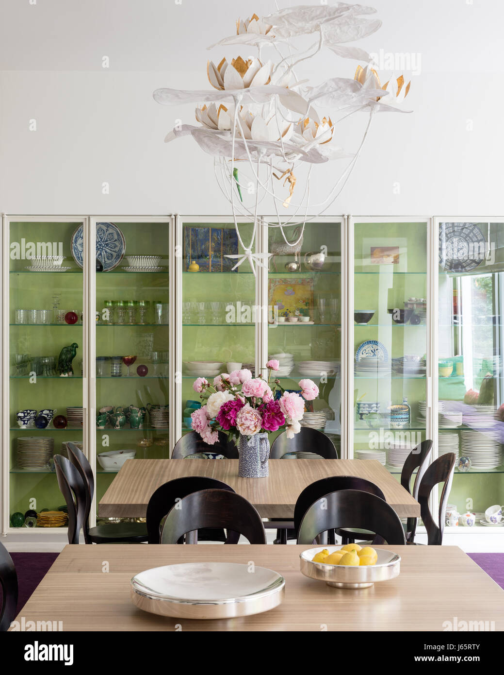 Gabinete de vidrio con un par de mesas de roble y sillas vintage permiten 16 sentados para cenar Foto de stock
