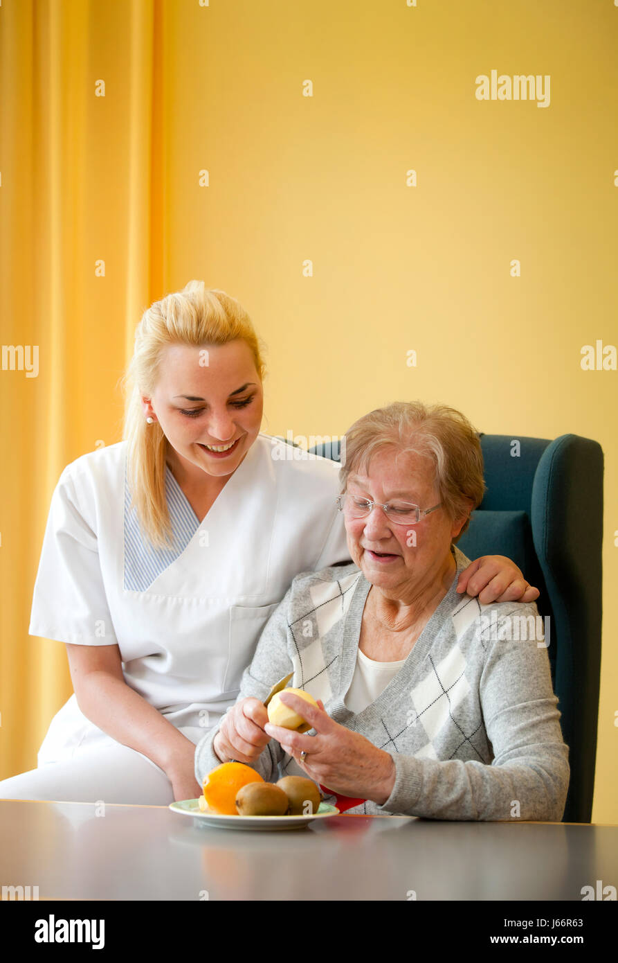 Día clínica de geriatría. Una mujer joven en el voluntariado social, FSJ año social voluntario, admite un paciente en la vida diaria. Tagesklinik einer Foto de stock