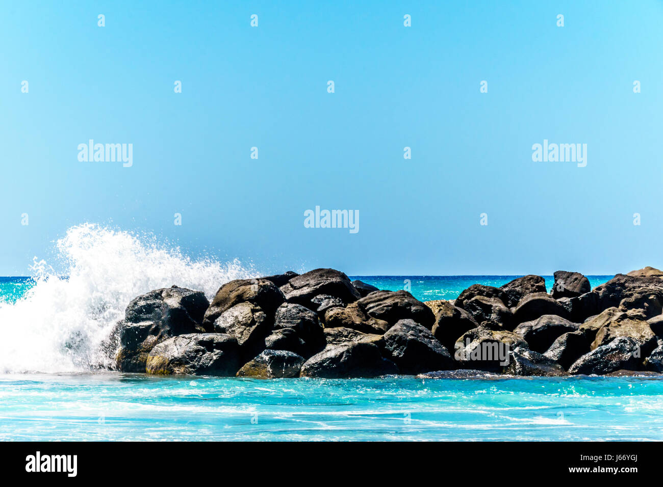 Olas rompiendo sobre las barreras que crean las lagunas de Ko Olina en la costa oeste de la isla hawaiana de Oahu. Las lagunas ideales para nadar Foto de stock
