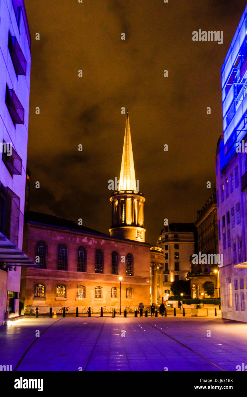 Todas las Almas' Iglesia, Langham Place, Londres, Reino Unido, por la noche, iluminado en naranja, la luz azul de la BBC Broadcasting House Foto de stock