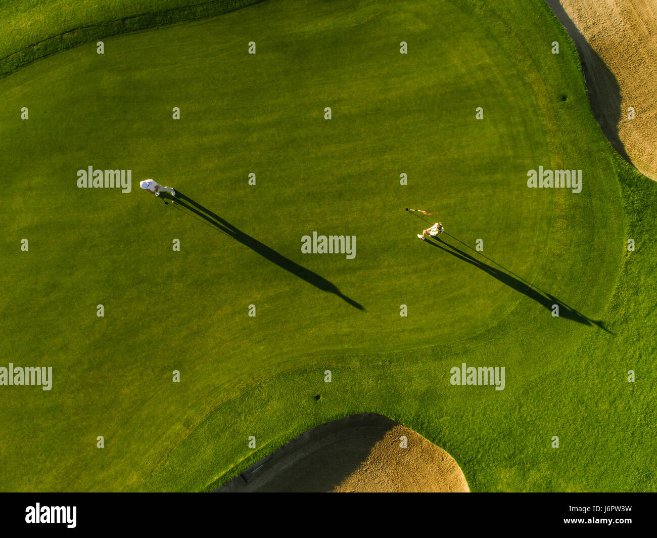 Vista aérea de los golfistas jugando en el putting green. Los jugadores profesionales en un green de golf. Foto de stock