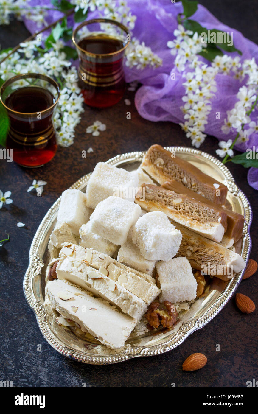 Rahat Lukum halva, sorbetes, y té en la mesa de la cocina. Dulces turcos y árabes. Ramadan alimentos. Foto de stock