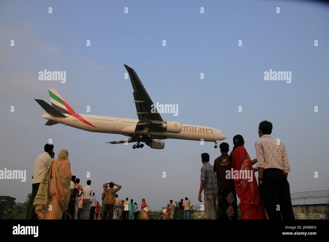 Las personas se reúnen en el lado norte del Aeropuerto Internacional Shahjalal para ver los aviones que aterrizan en el aeropuerto. Dhaka, Bangladesh. Foto de stock