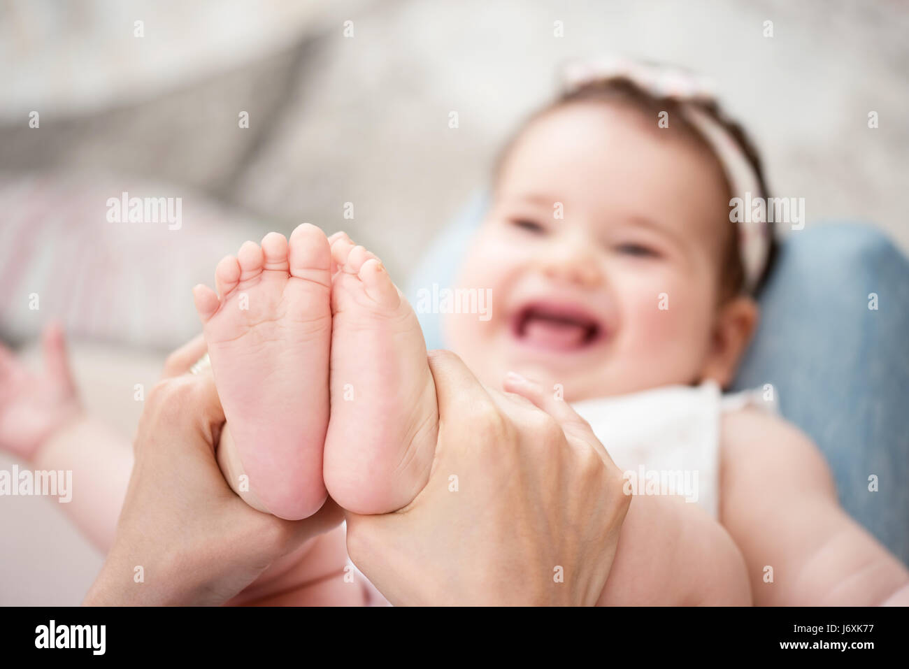 Madre masajeando su bebé niña Foto de stock