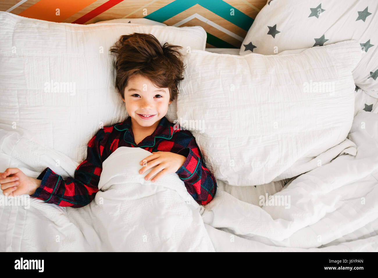 Retrato de un sonriente niño acostado en la cama Foto de stock