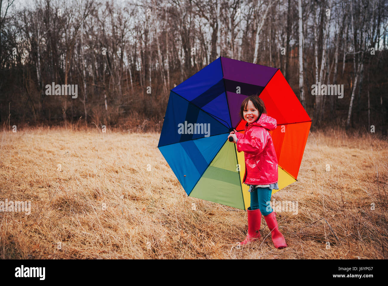 Chica sosteniendo un paraguas multicolor Foto de stock