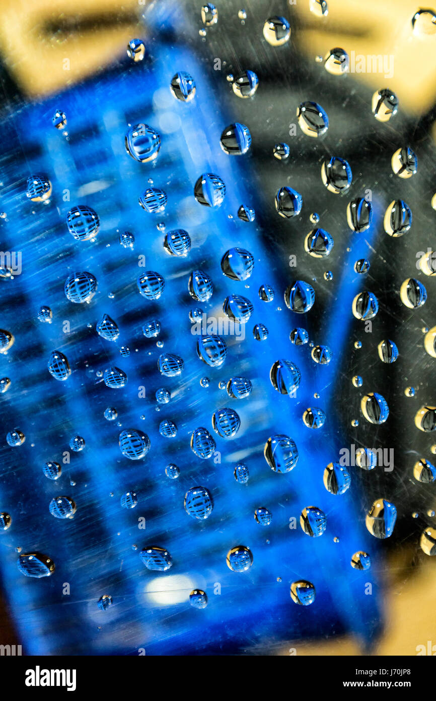 Las gotas de agua con reflexiones sobre un fondo azul. Foto de stock