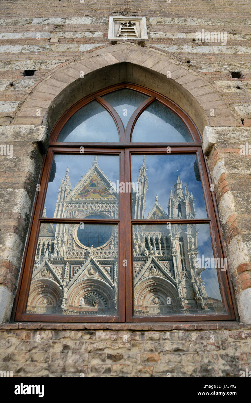 Fachada de la catedral de Siena (Domo) el reflejo en la ventana de Santa María della Scala. Foto de stock