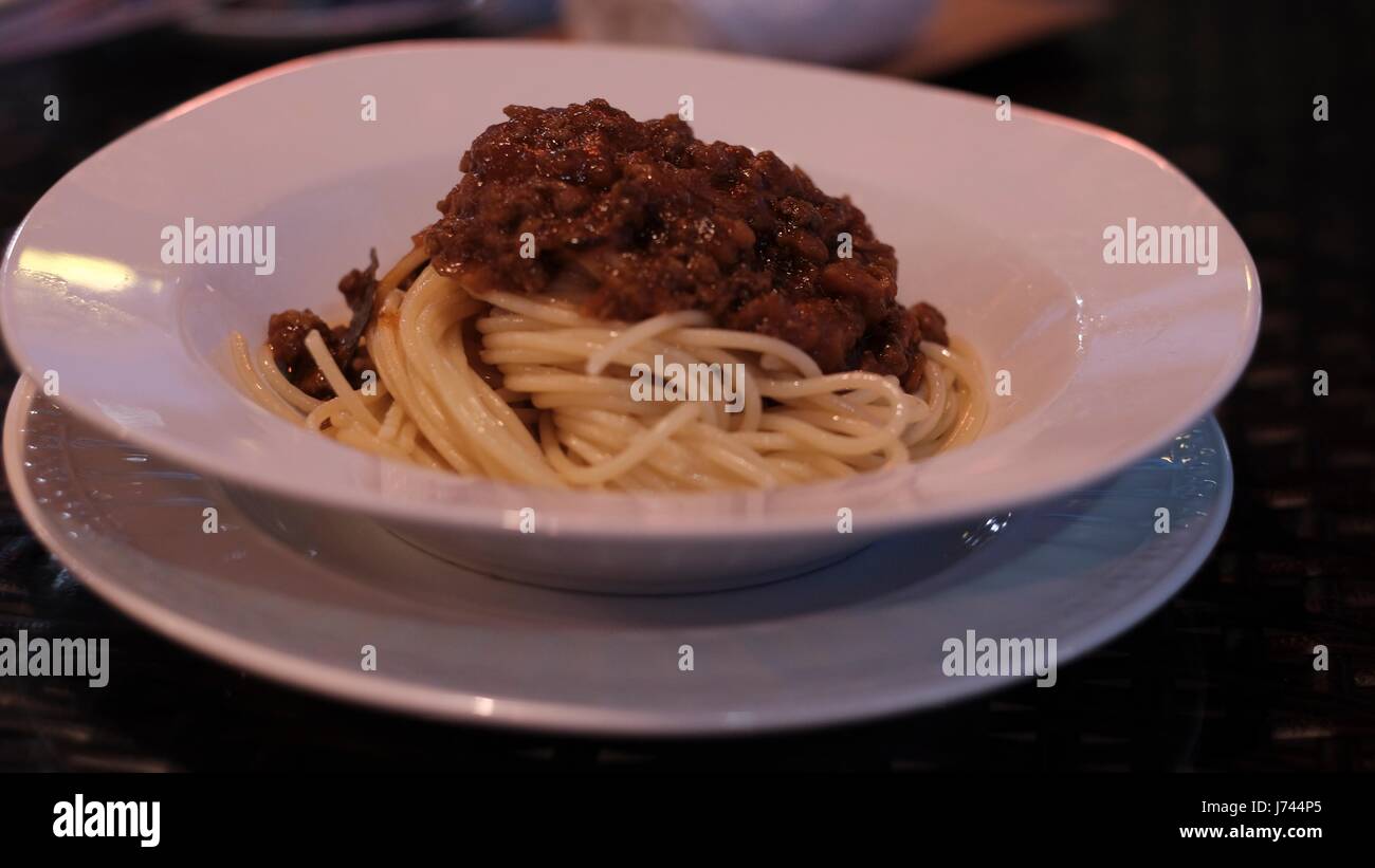 Spaghetti Bolognese Cocina Italiana Clásica. Servido en un tazón blanco en un plato Pasta con salsa de carne y tomate en Pattaya Tailandia Foto de stock