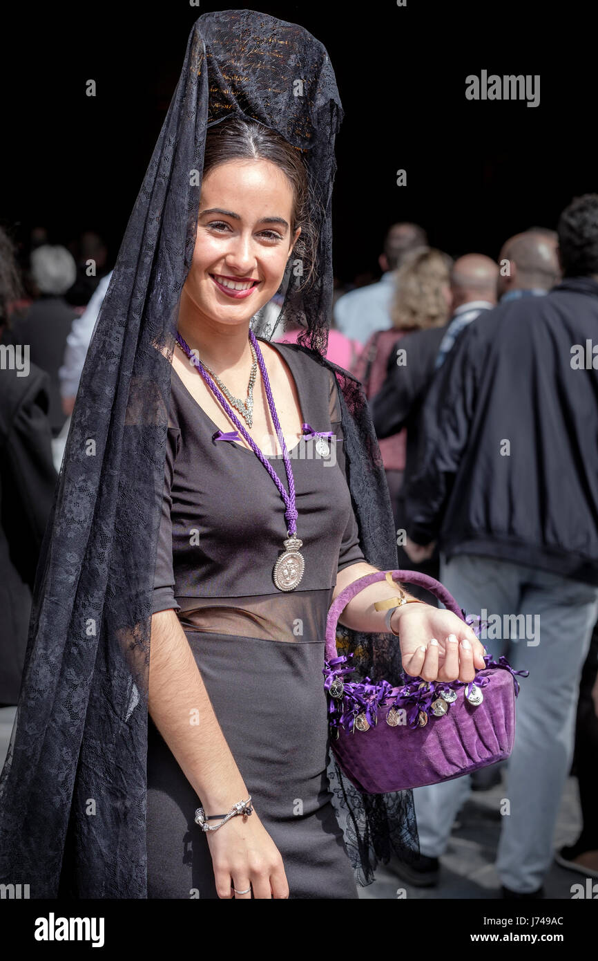 Mujer vestida de una manera muy pasada de moda con la tradicional  'Mantilla' y 'peineta'. En Sevilla, durante lo que se conoce como 'Jueves  Santo' o Jueves Santo Fotografía de stock -