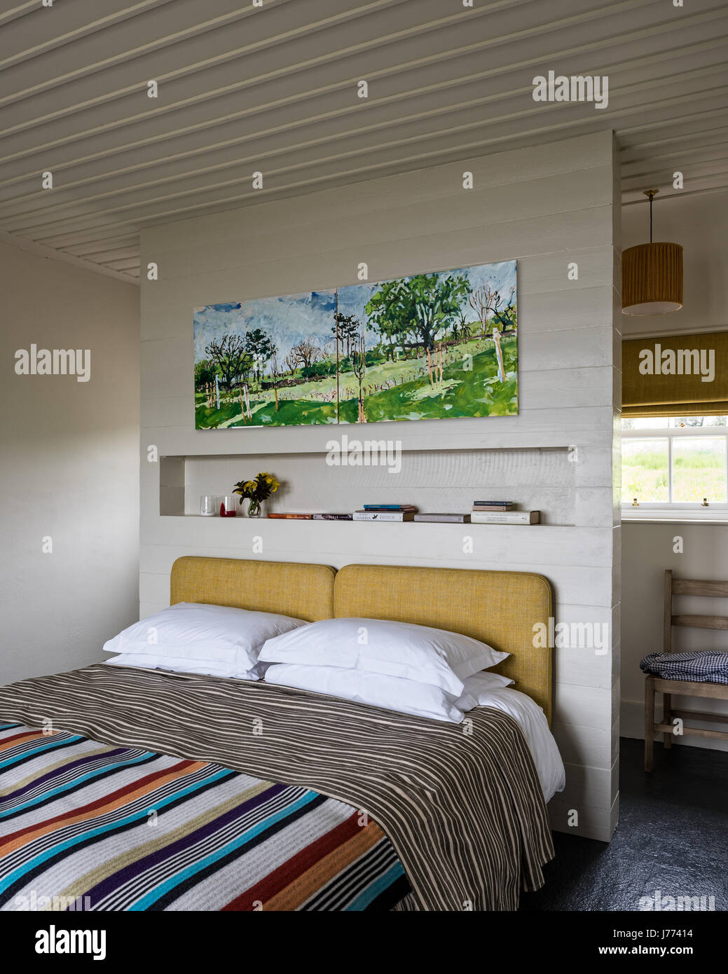 Acogedor dormitorio con cama grande, cojines decorativos y paredes a rayas  en blanco y azul Fotografía de stock - Alamy