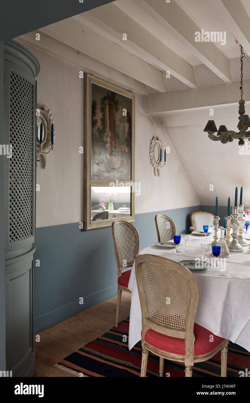 Candelabros de plata en la mesa de comedor con rincón, armario con espejo trumeau francés del siglo XVIII. Foto de stock