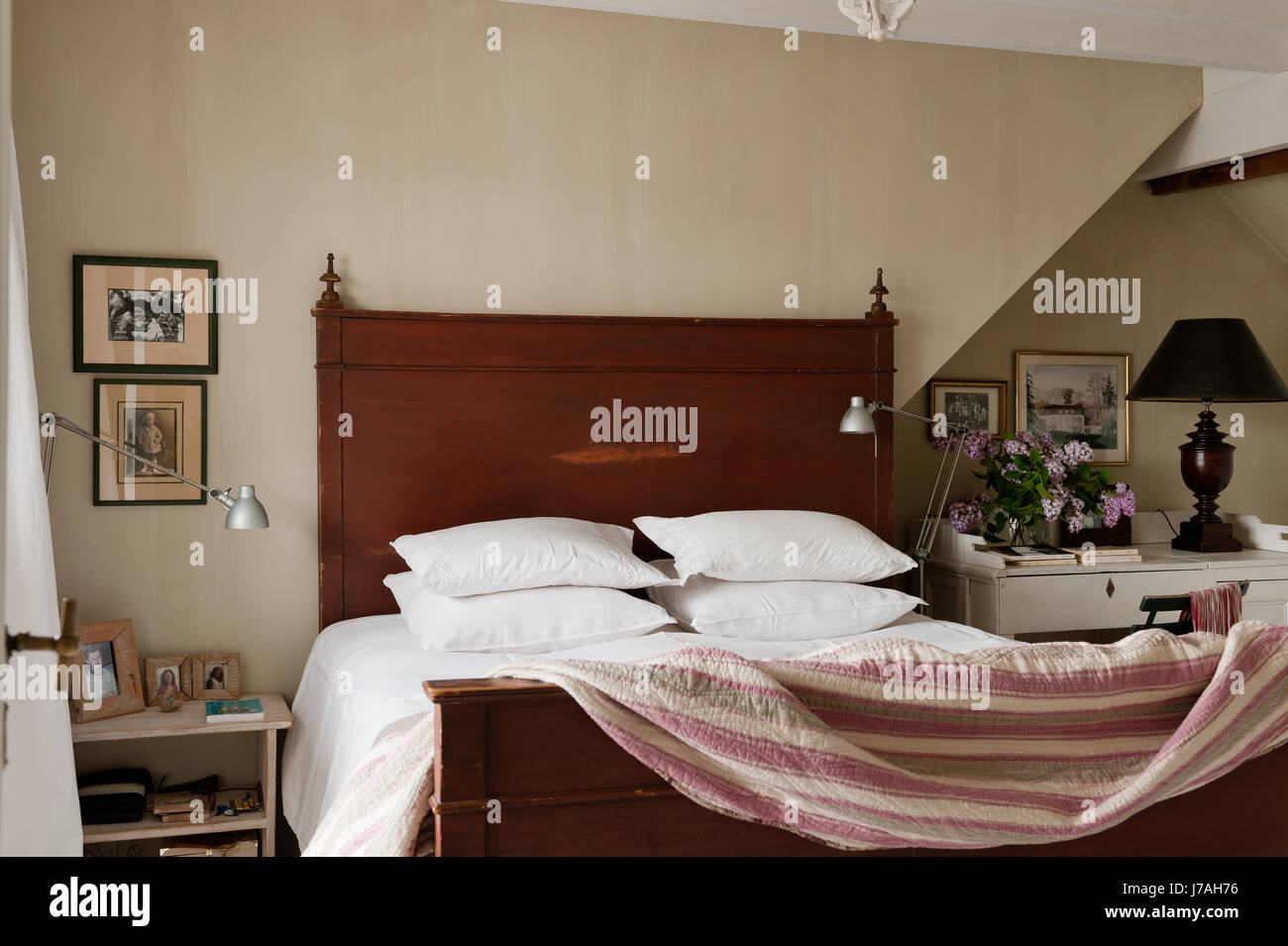 Las almohadas apiladas en cama de madera con edredón Foto de stock