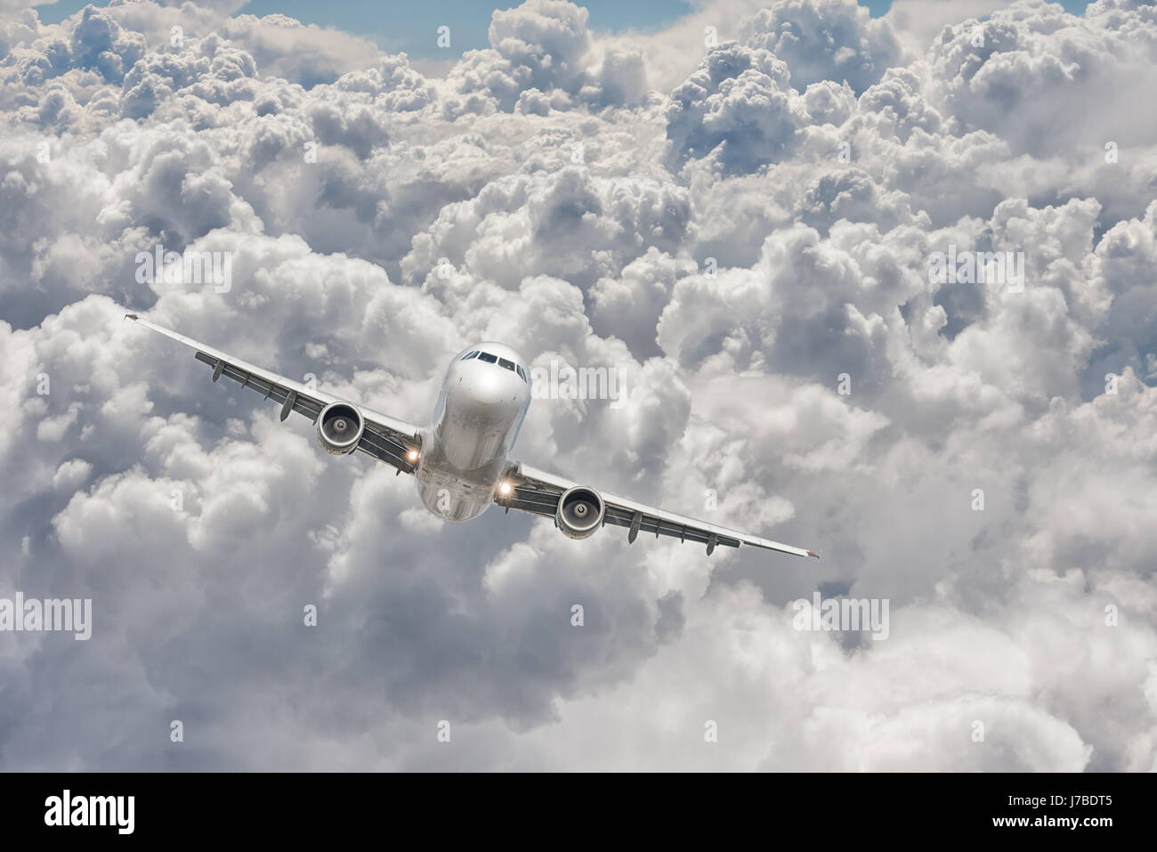 Vista frontal de un gran avión volando a través de las nubes Foto de stock