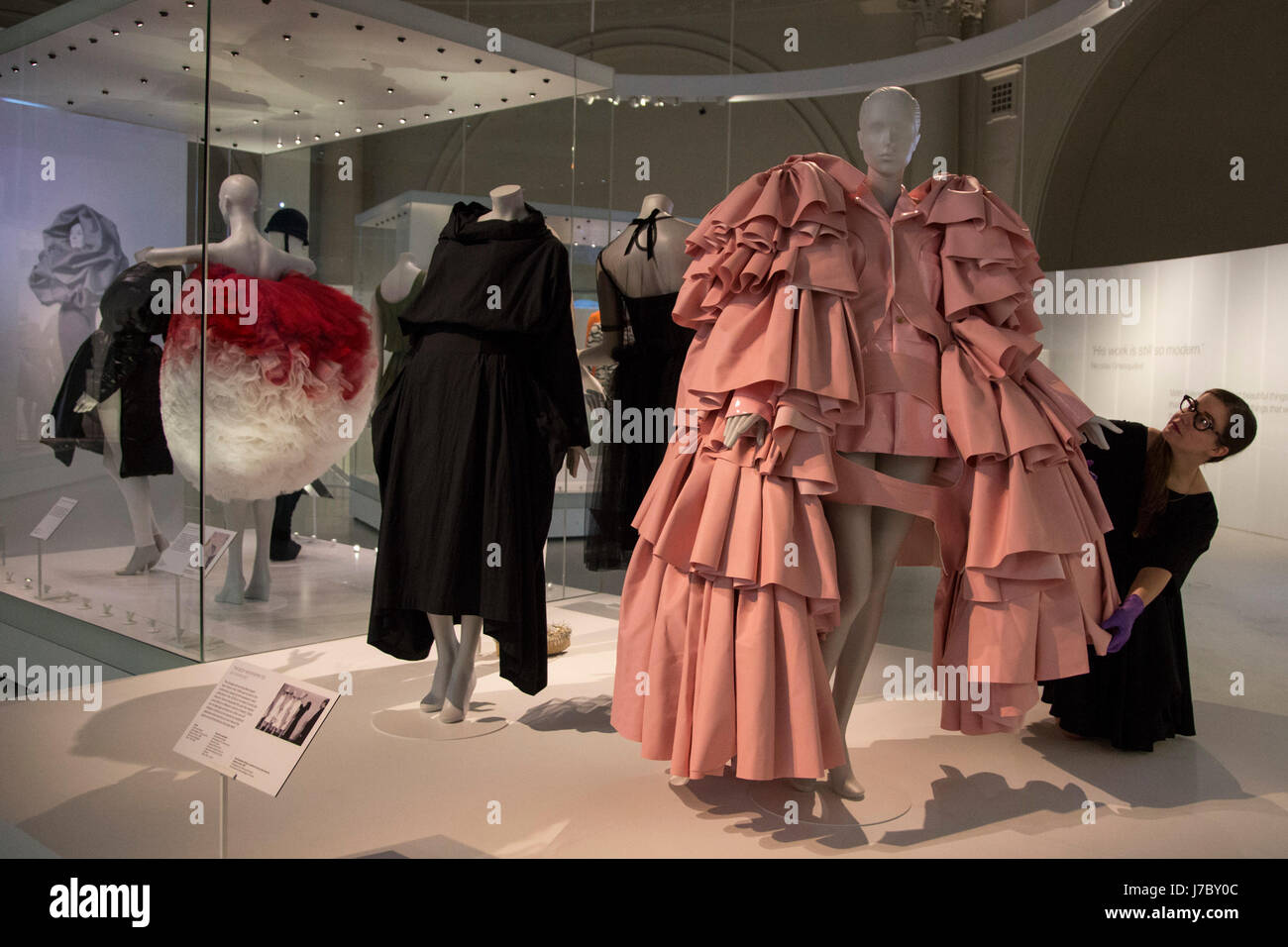 Londres, Reino Unido. 24 de mayo de 2017. Un empleado del museo Balenciaga  ajusta la mujer inspirada de ensemble, poliuretano vestido de cuero por Rei  Kawakubo de Comme des Garcons, Tokio, 2016.