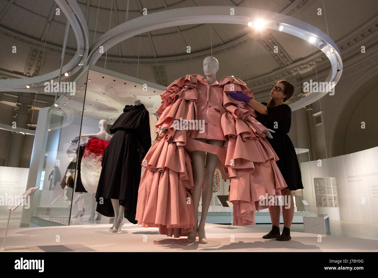 Londres, Reino Unido. 24 de mayo de 2017. Un empleado del museo Balenciaga  ajusta la mujer inspirada de ensemble, poliuretano vestido de cuero por Rei  Kawakubo de Comme des Garcons, Tokio, 2016.
