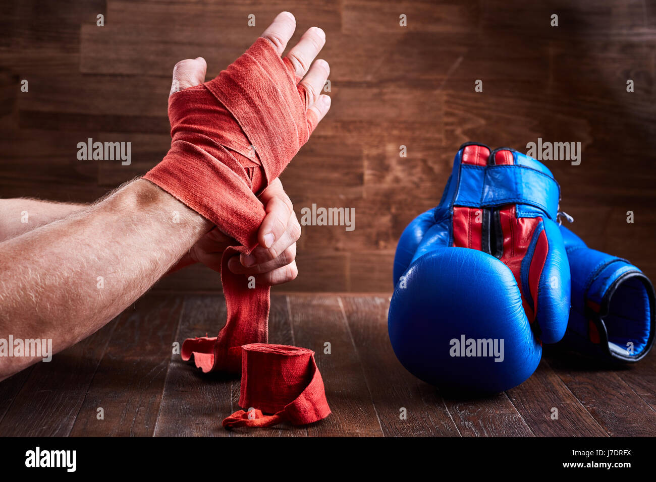 Hombre deportivas envolver su manos con guantes de boxeo y cinta