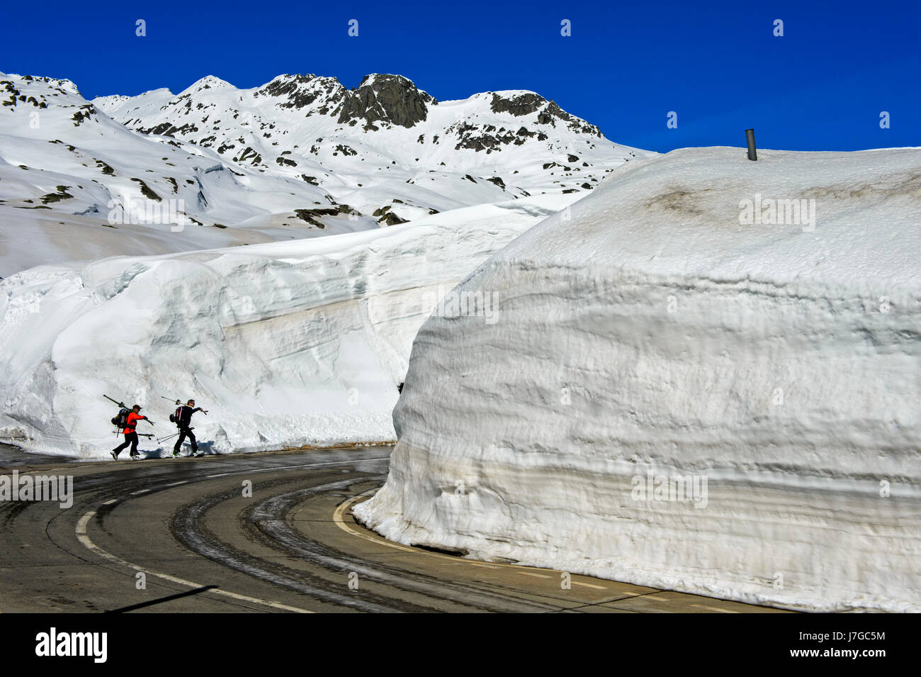 Dos esquiadores en frente de altas paredes de nieve, circunvalación del Gotthard, Canton Ticino, Suiza Foto de stock