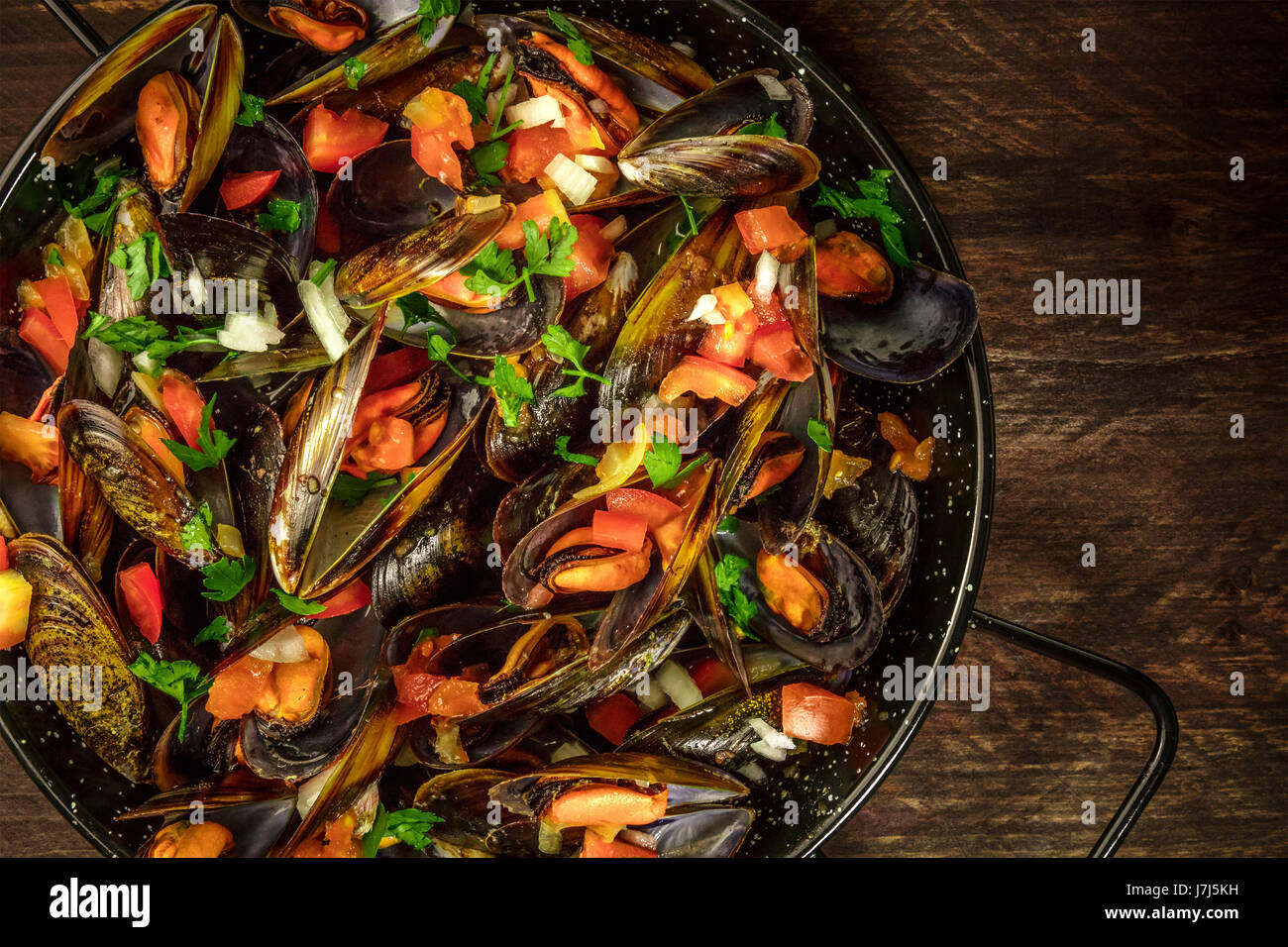 La sartén de mejillones marinara sobre fondo rústico con copyspace Foto de stock