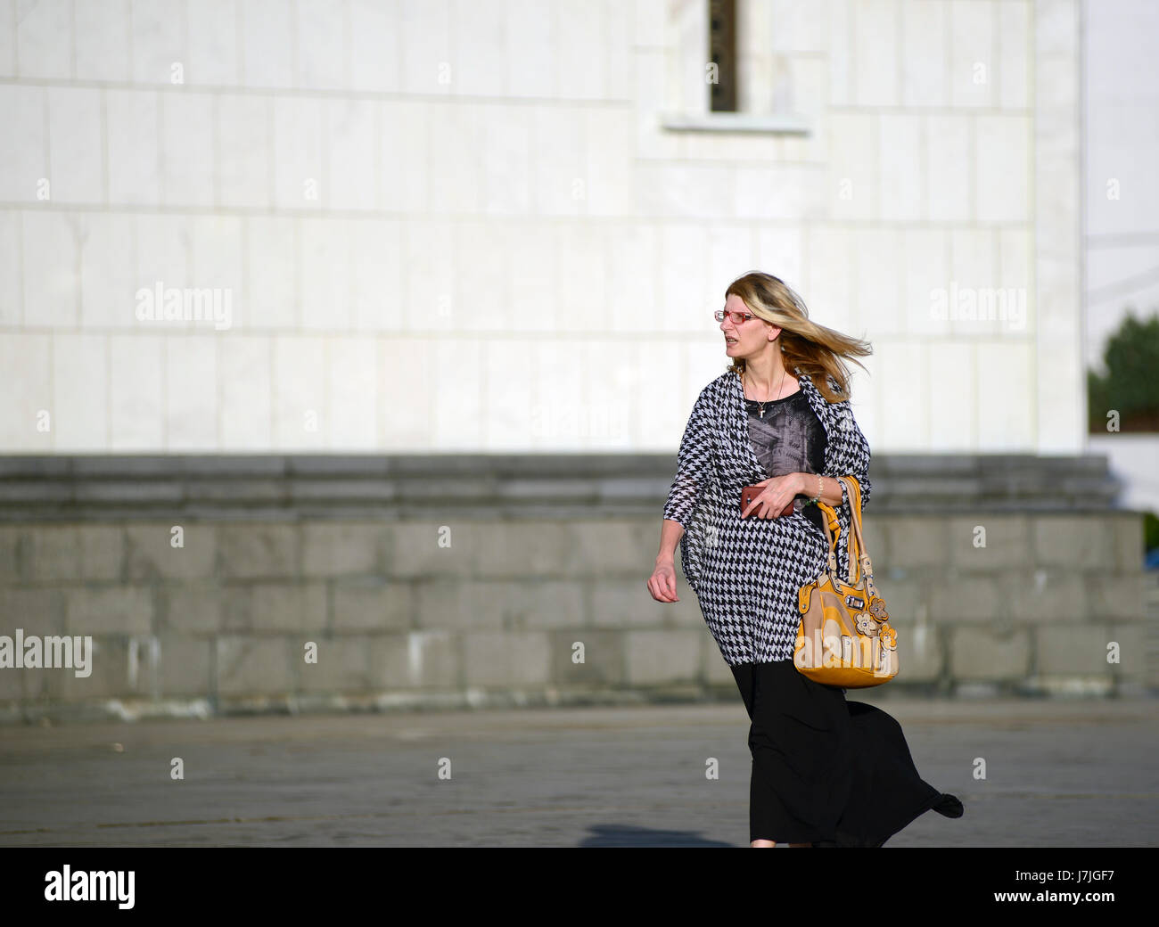 Mujer rubia caminando junto a la Iglesia de Saint Sava, Belgrado (Serbia) Foto de stock