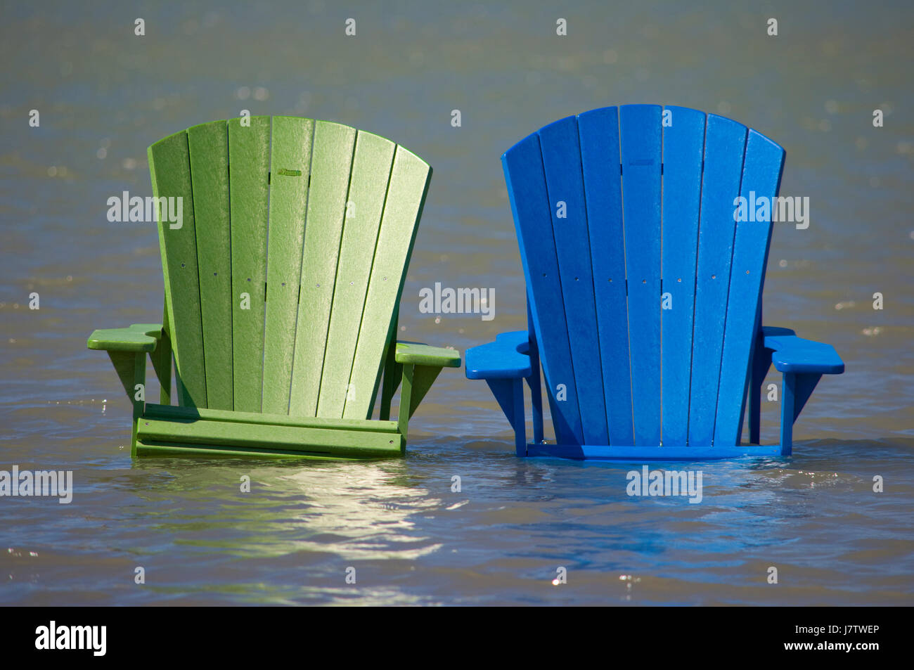 Muskoka sillas parcialmente sumergido en el agua y la arena después de las inundaciones de primavera y gran lago de aguas en Toronto, Ontario, Canadá Foto de stock